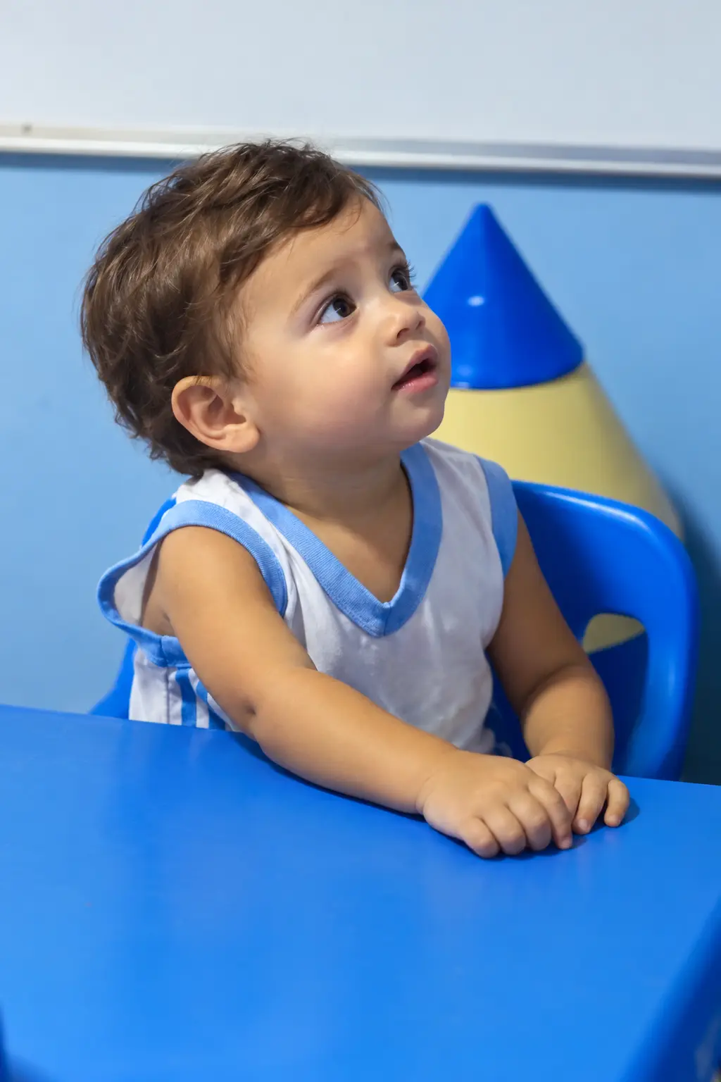 Aluno pequeno da turma Baby da Escola Aplicação sentado à mesinha azul
